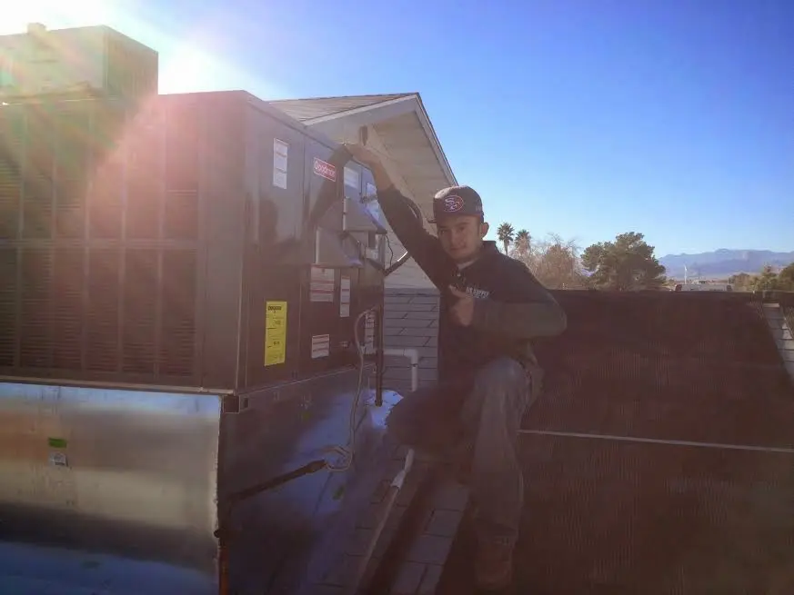 HVAC technician performing AC Tune-Up on a rooftop unit in Longswamp